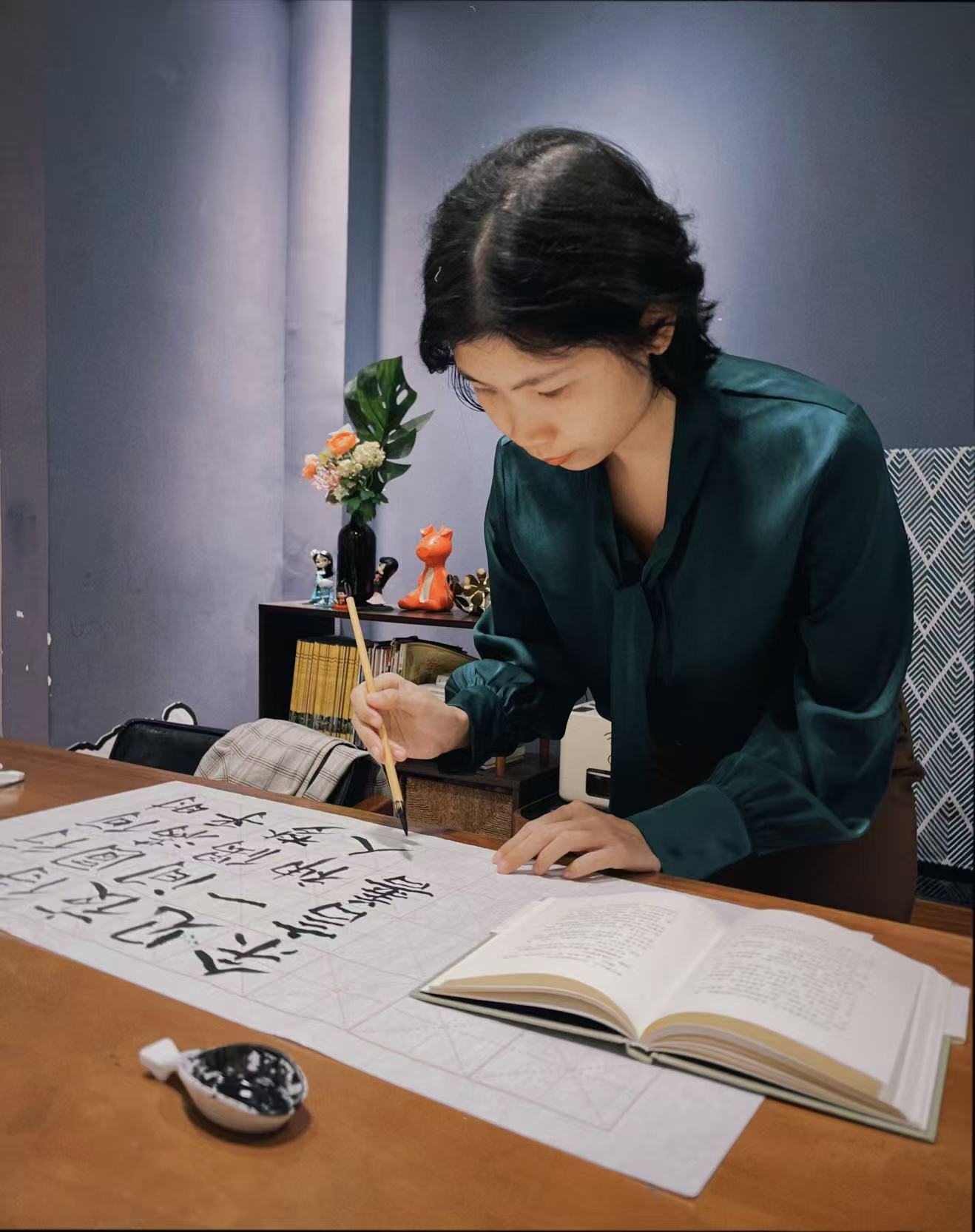 Xiaoen practising Chinese calligraphy with brush and ink